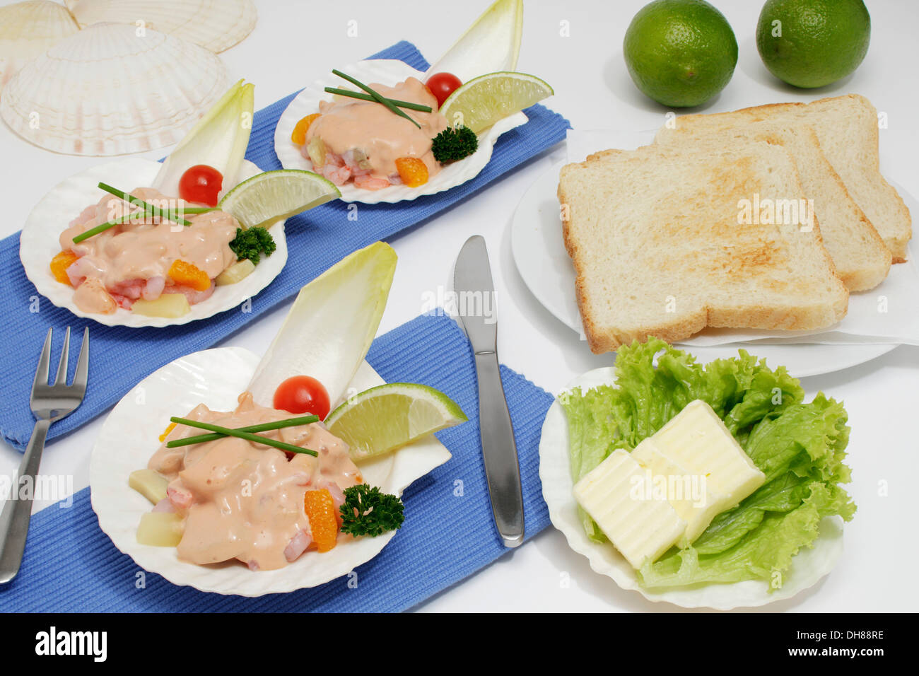 Krabbencocktail in eine Jakobsmuschel, Limetten, Toast, butter Stockfoto