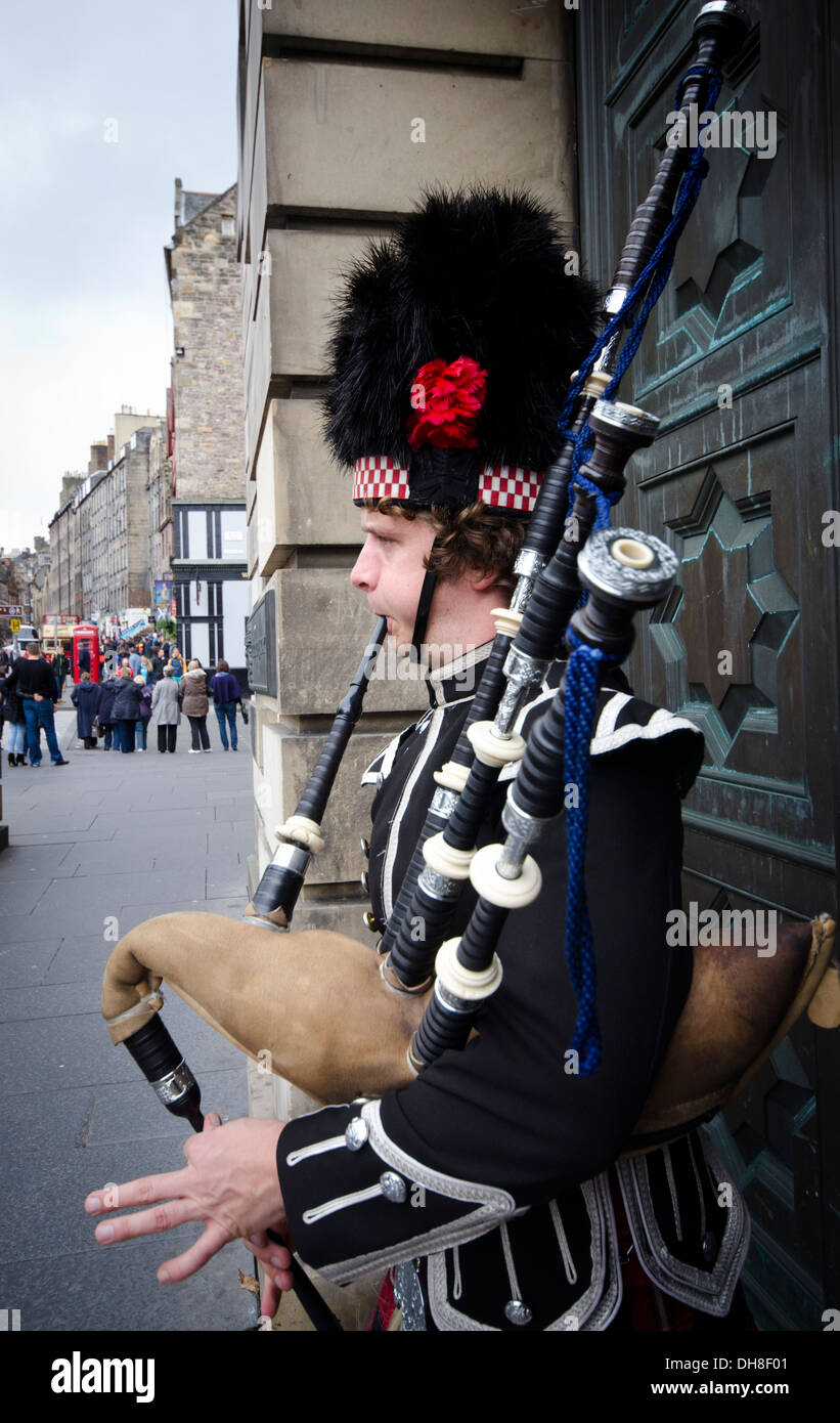 Piper in traditioneller Tracht Dudelsack vor große Tür auf der Royal Mile in Edinburgh Stockfoto