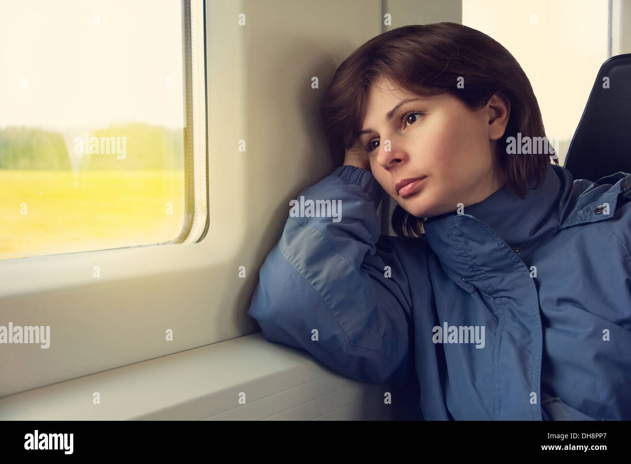 Junge Frau reist mit dem Zug, Blick zum Fenster Stockfoto