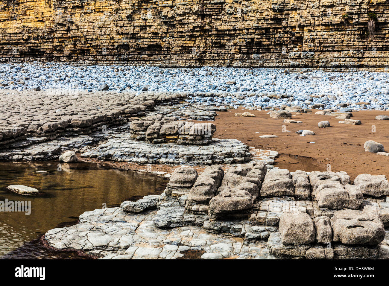 Gesteinsschichten in der Felswand und Strand von Nash Point in Wales. Stockfoto