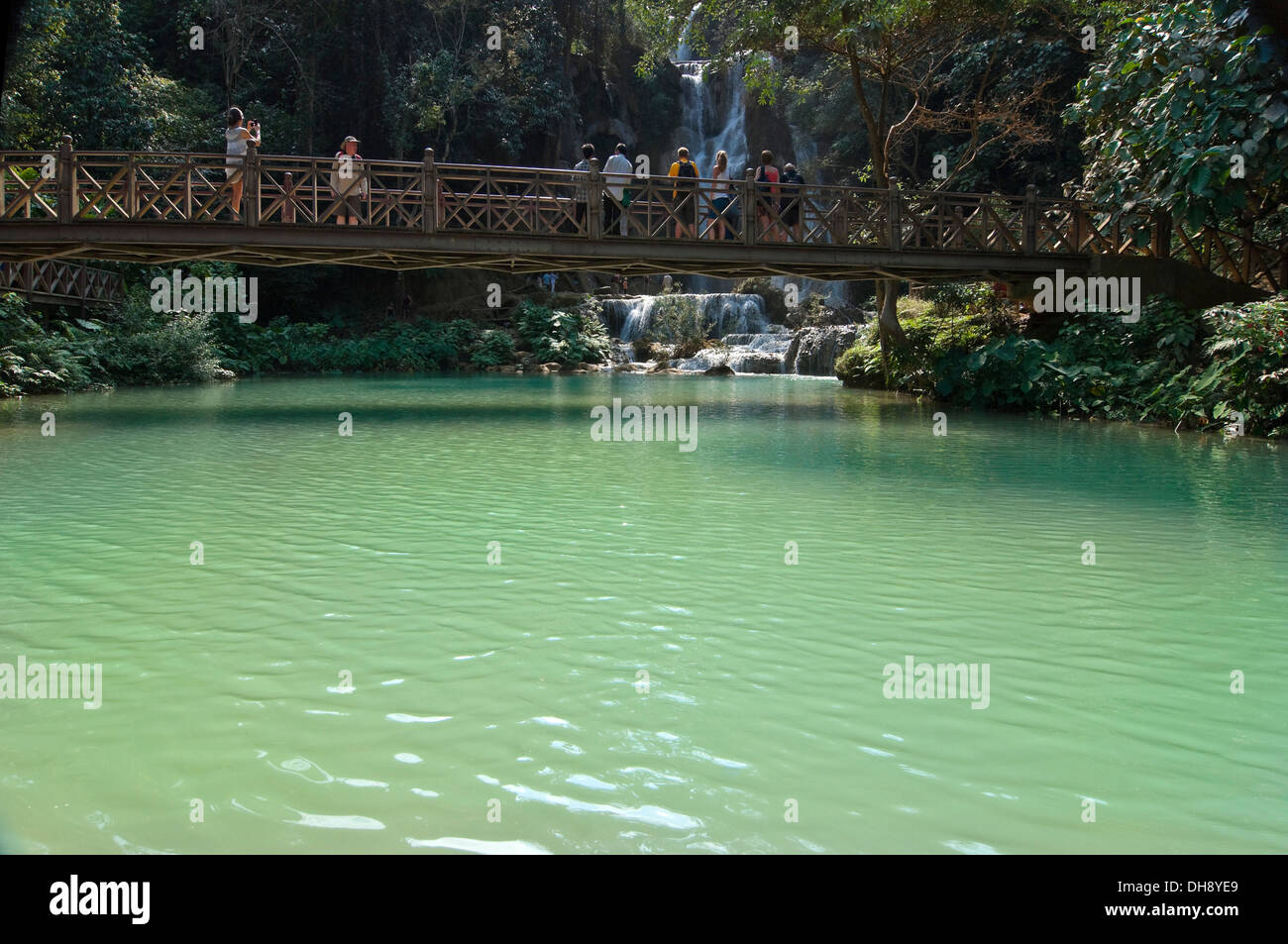 Horizontale Ansicht von Touristen fotografieren von der Brücke über den malerischen Kuang Si Wasserfällen in Laos. Stockfoto