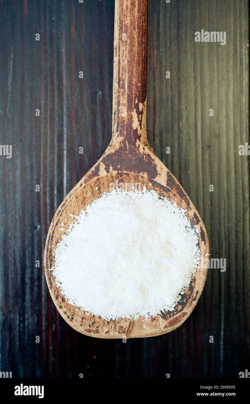 Kokosraspeln auf alten Holzlöffel Stockfoto