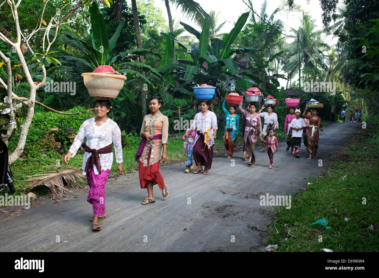 Frauen Fuß A Straße mit Körben auf ihren Köpfen in Kuningan Festival; Bali, Indonesien Stockfoto