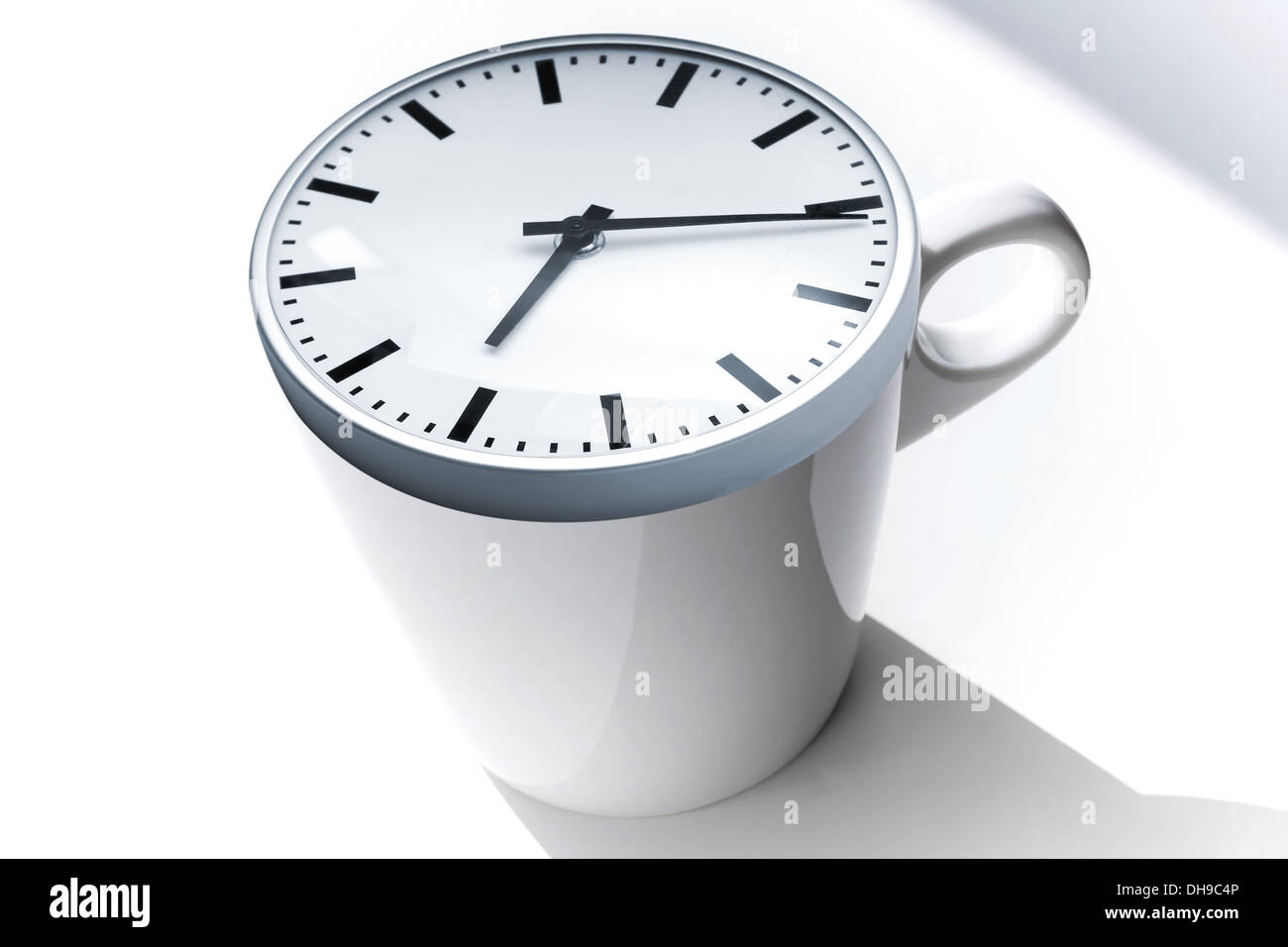 Coffee Break Metapher. Weiße Keramik Tasse mit modernen Uhr an der Spitze Stockfoto