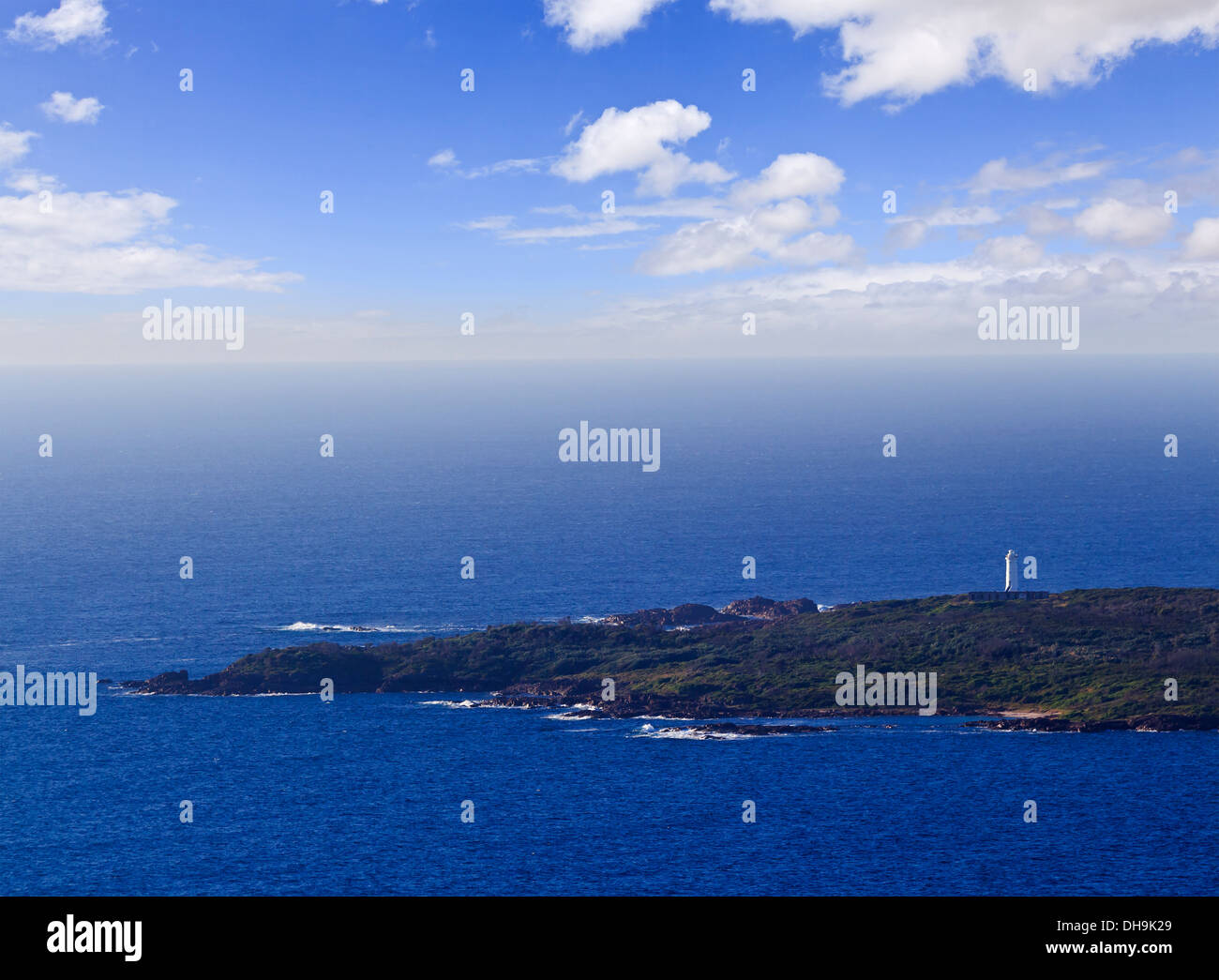 einsamer Leuchtturm Turm weitläufig auf isolierte Insel im offenen Meer Tageszeit als nautische Wahrzeichen Ansicht gegen Horizont Stockfoto