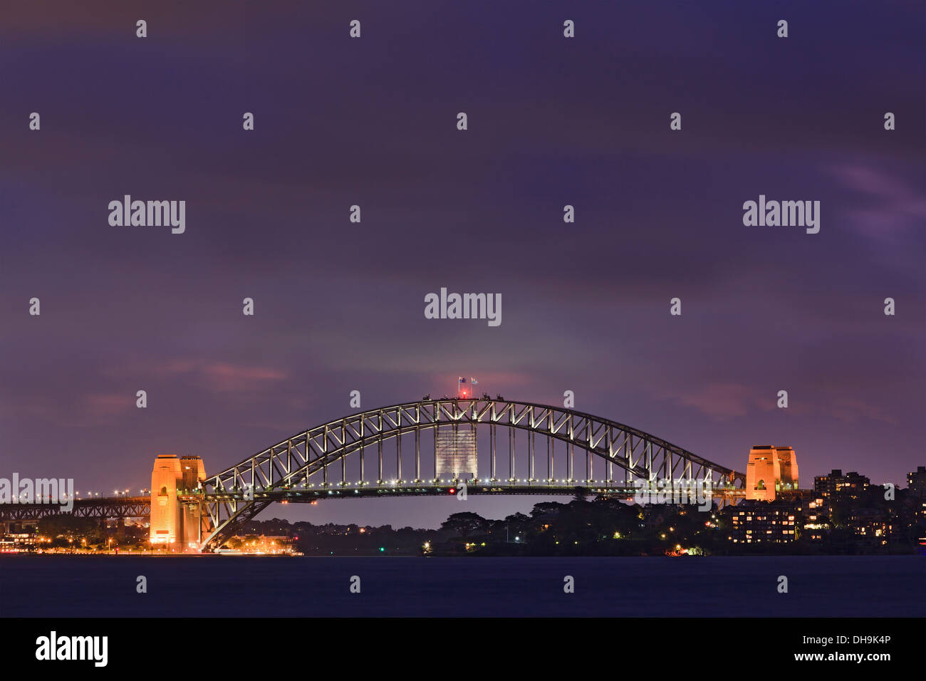 Sydney Harbour Bridge Stadtseite bei Sonnenuntergang beleuchtet mit Lichter dunklen Wolkenhimmel Panorama Seitenansicht anzeigen Stockfoto