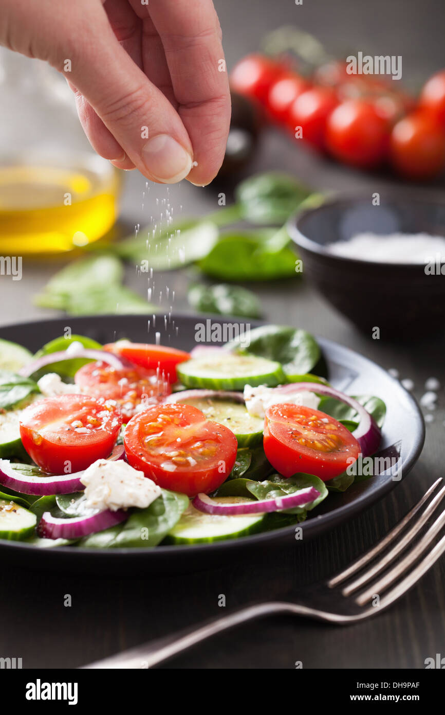 Hand, die Zugabe von Salz, Gemüsesalat Stockfoto