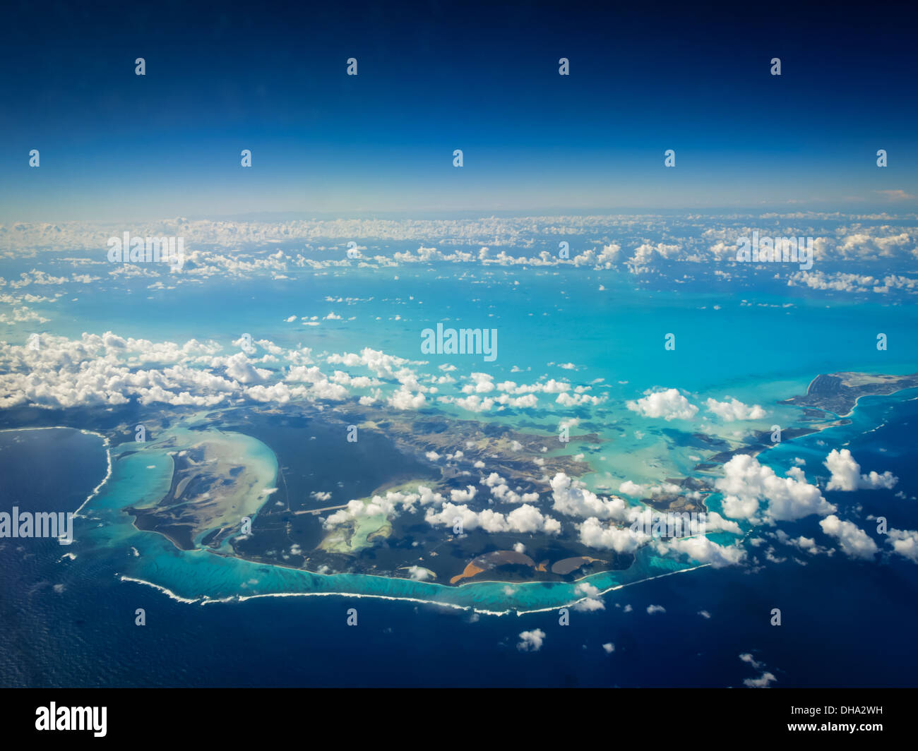 Blick aus der Vogelperspektive auf die bunte Kette tropischer Inseln mit Korallenriffen, Sandbänken, Salzbecken und Wolken Stockfoto