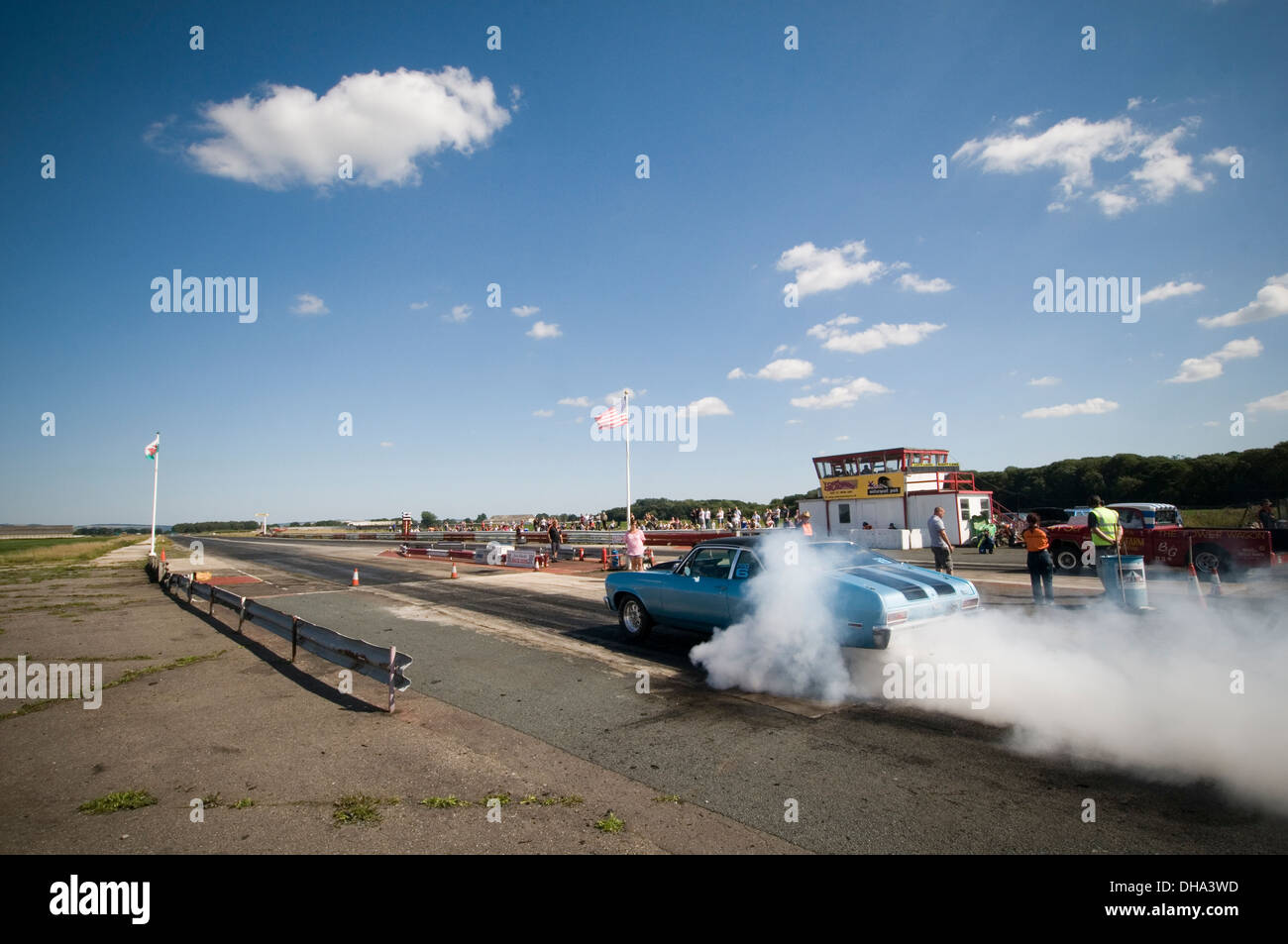 Muscle-Car Autos tun einen Burnout an einen Dragstrip, drehen die Räder Reifen Ausbrennen smokey Rauch Kautschuk glatt Slicks Heizung dr Stockfoto