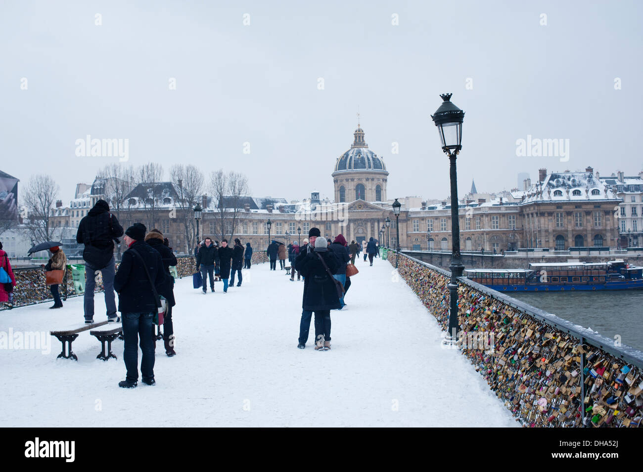 Paris, Frankreich - Touristen in Pont des Arts an einem schnupfigen Wintertag Stockfoto