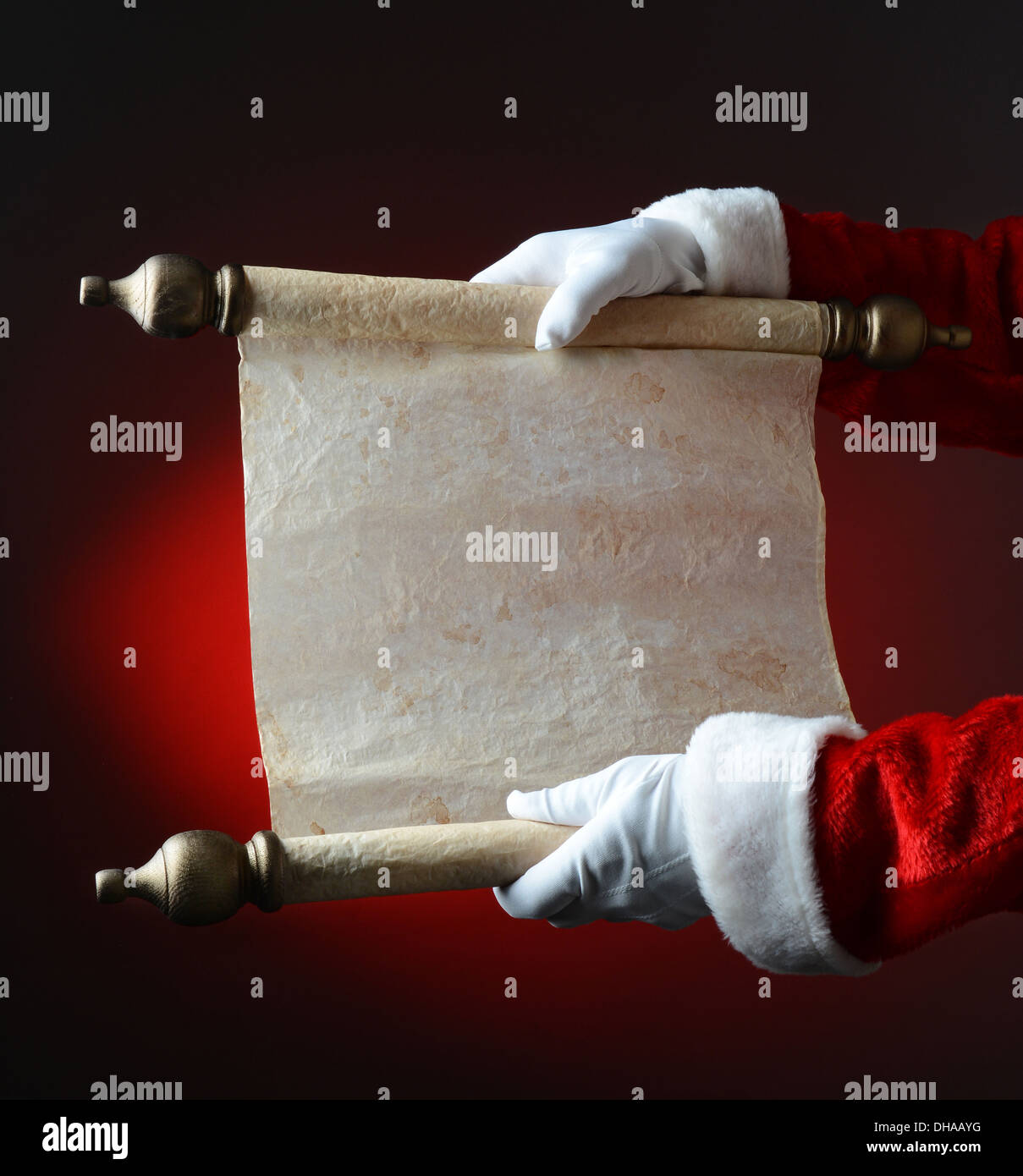 Santa hält frech und schön Scroll über eine leichte bis dunkelroten Hintergrund. Die Schriftrolle ist leer, bereit für Ihre Kopie. Stockfoto