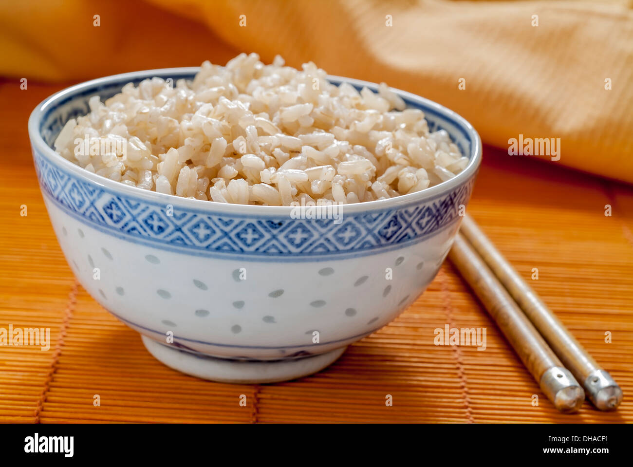 Brauner Reis in eine blaue und weiße chinesische Schüssel mit Stäbchen. Stockfoto