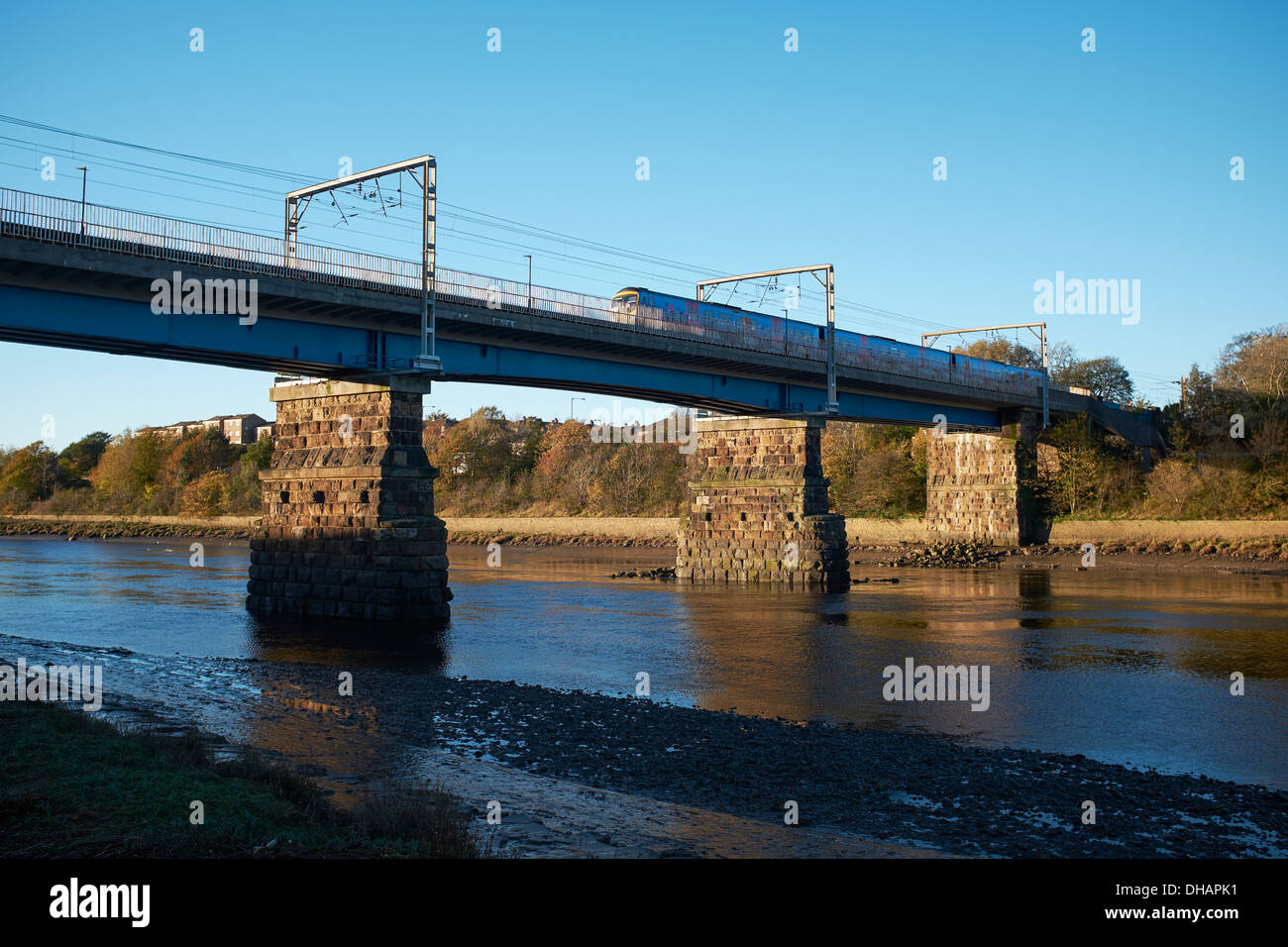 Personenzug auf der Eisenbahnbrücke überquert den Fluss Lune in Lancaster UK Stockfoto