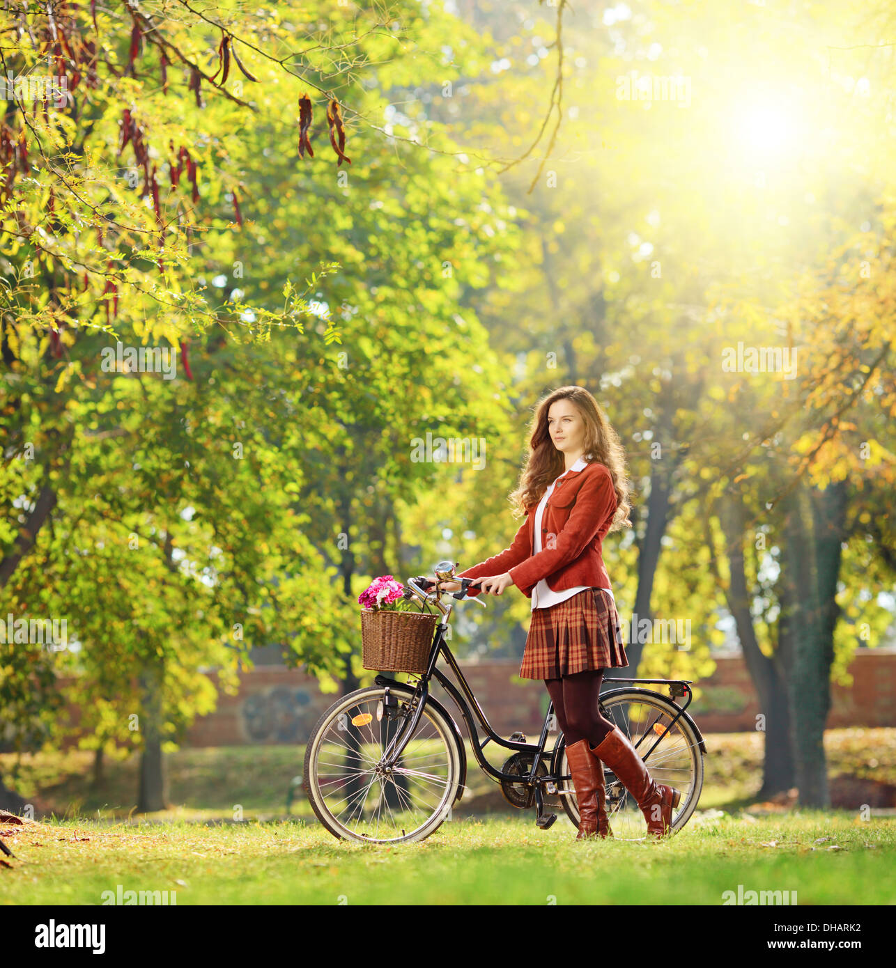 Junge Frau mit Fahrrad entspannend in einem Park an einem sonnigen Tag Stockfoto
