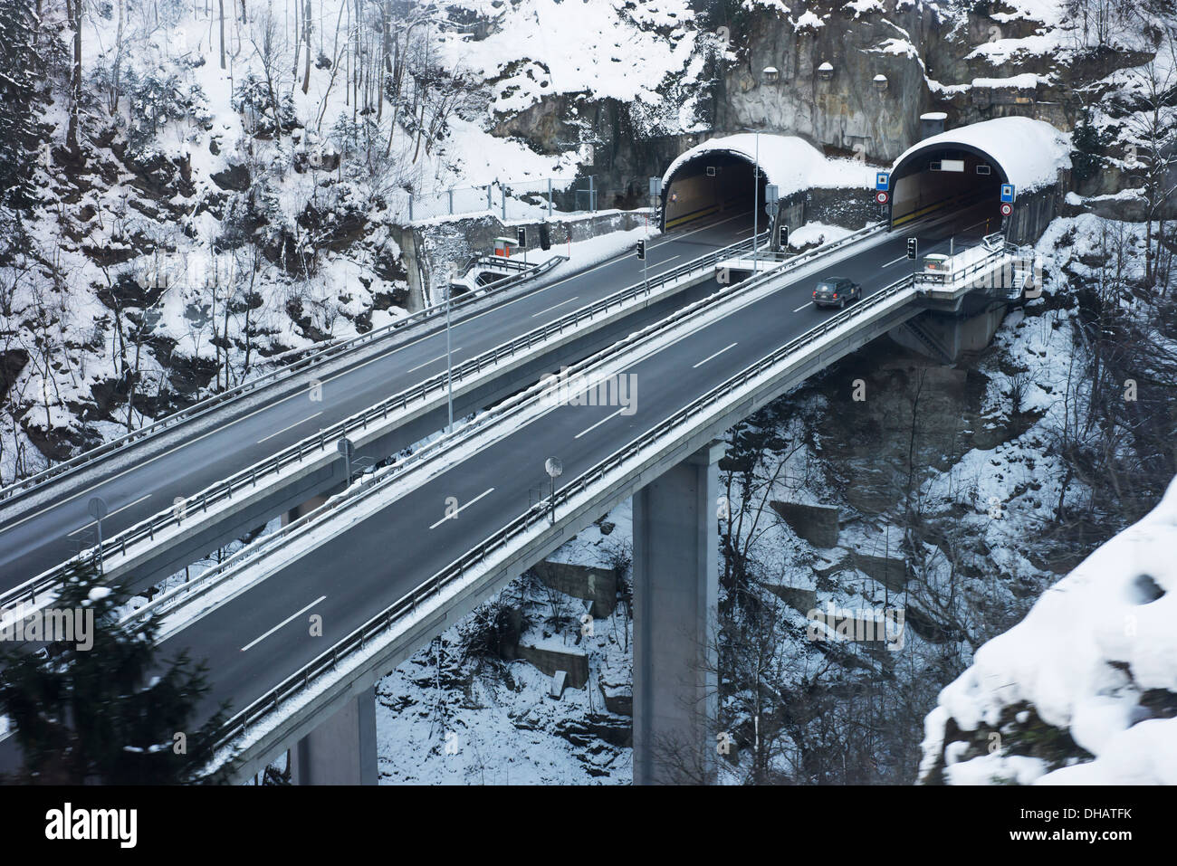 Straßen und Tunnel nebeneinander führen in und aus einem Berghang; Kanton Uri, Schweiz Stockfoto