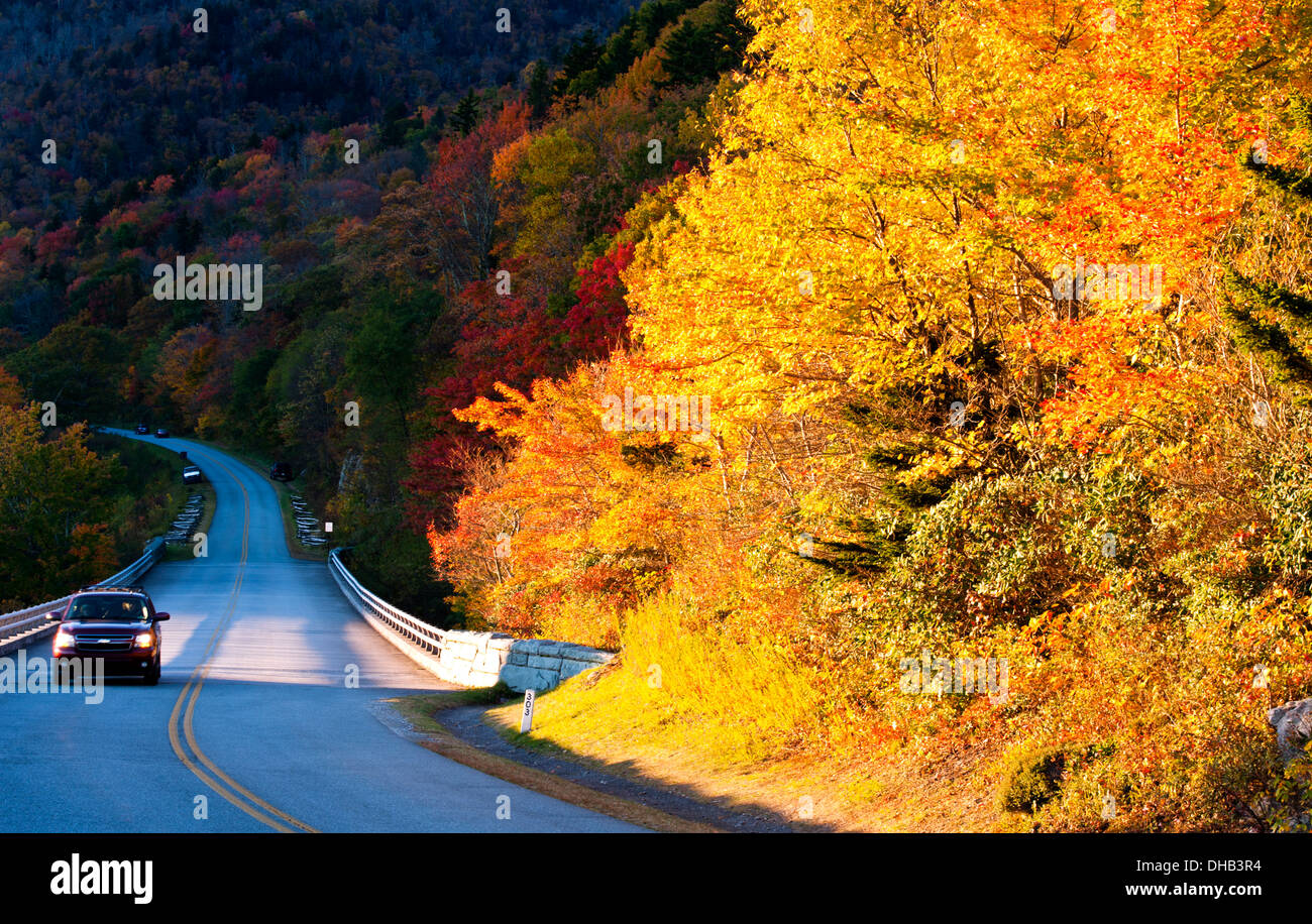 Auto mit Scheinwerfern auf und Herbst Farbe auf den Blue Ridge Parkway in der Nähe von Linn Cove Viaduct in Boone, North Carolina Stockfoto