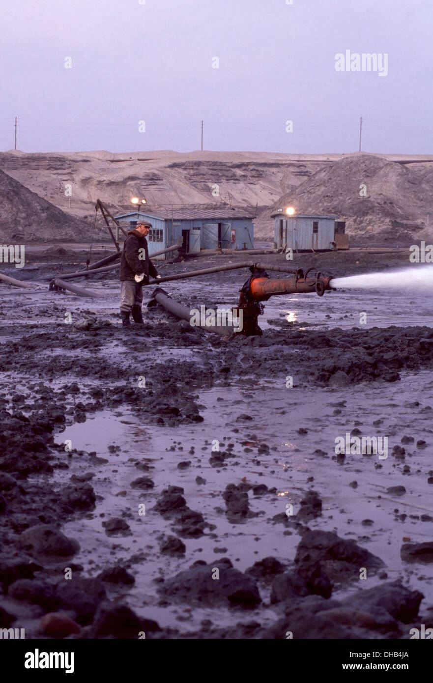 Workman sprüht ein Wasserwerfer auf den blauen Ton innerhalb der Tagebau Palmnicken Amber Mine an der Ostsee, Russland Stockfoto