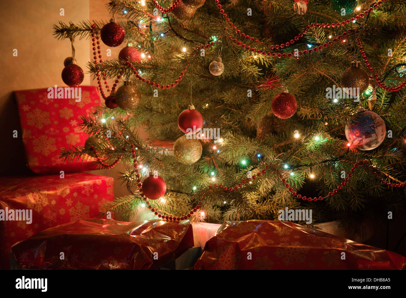 Beleuchtete Weihnachtsbaum in der Nacht mit Geschenke-Teil des Baumes Stockfoto