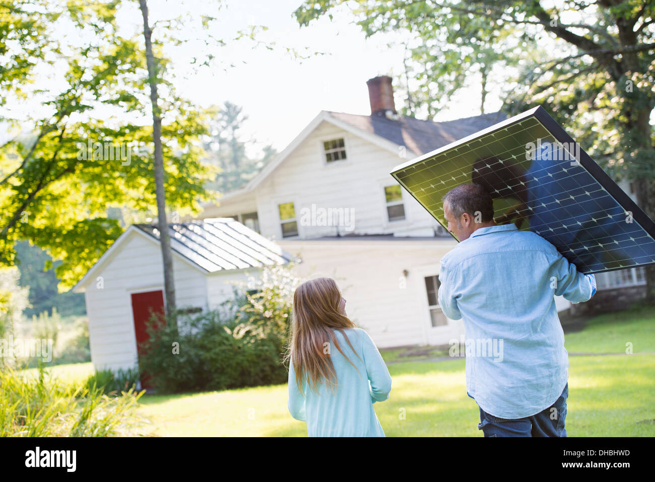 Ein Mann mit einem Solar-Panel für ein Gebäude im Bau. Stockfoto