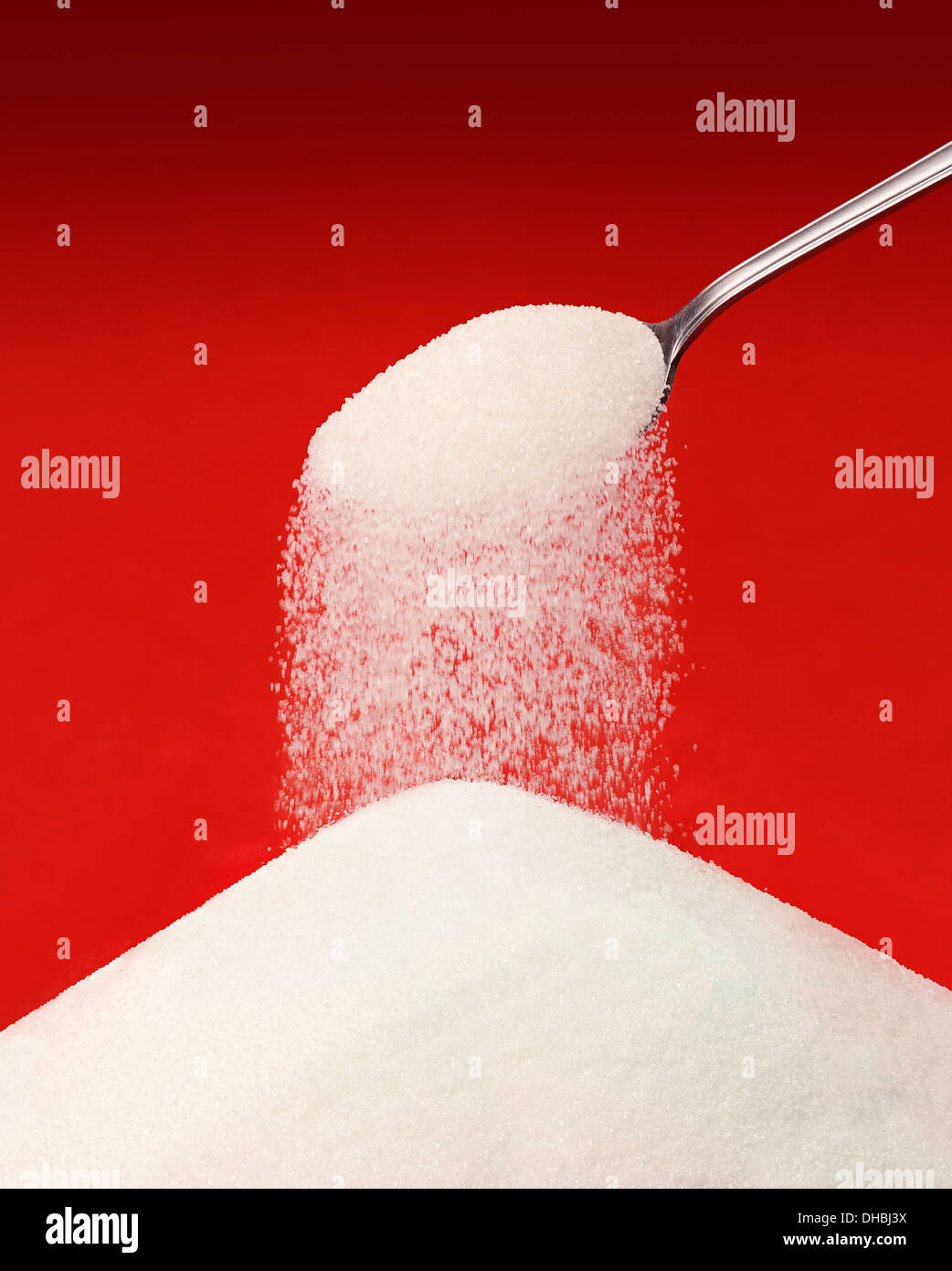 Zucker aus einem Löffel Gießen. Stockfoto