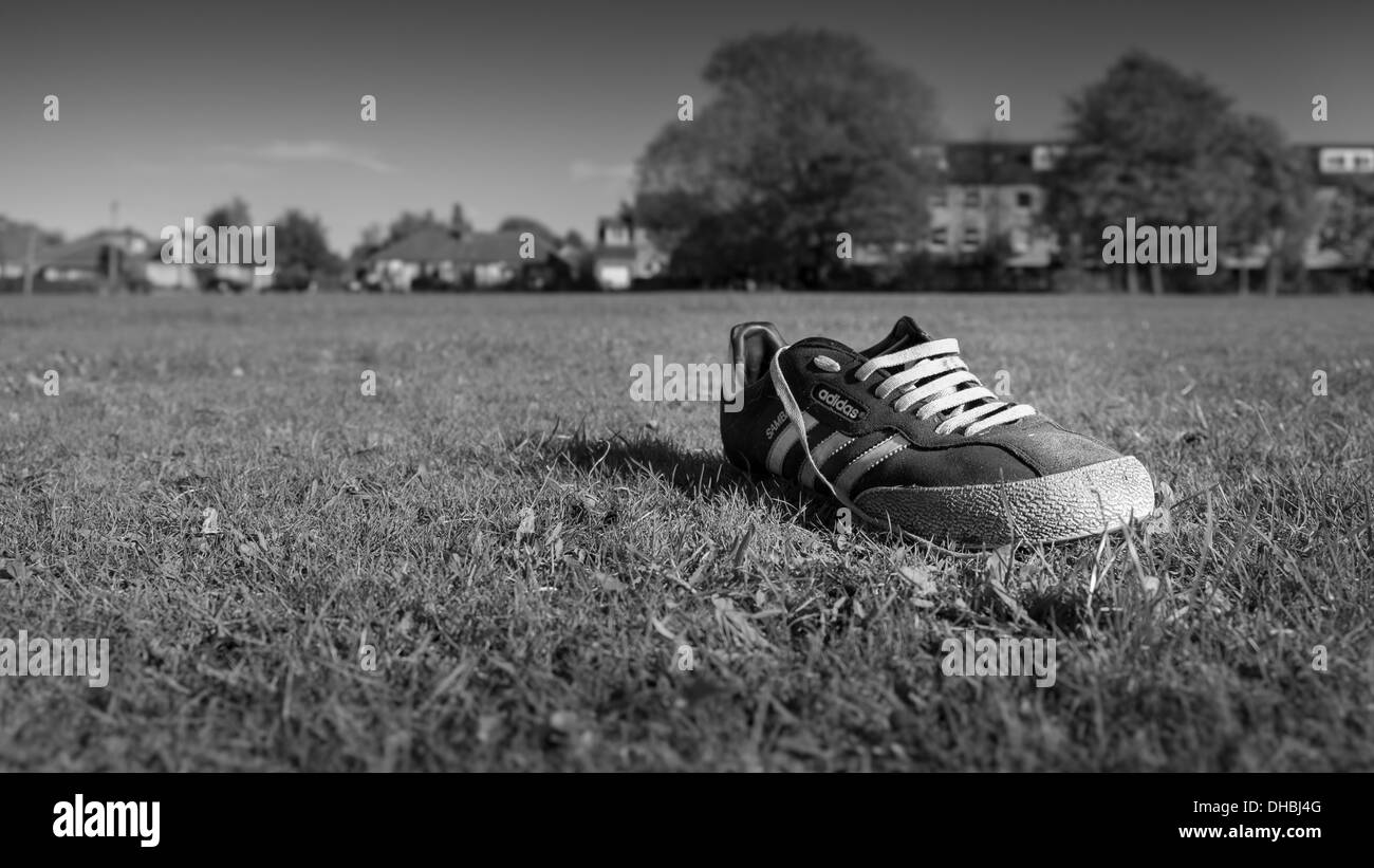 verlassene Schuh am Fußballplatz Stockfoto