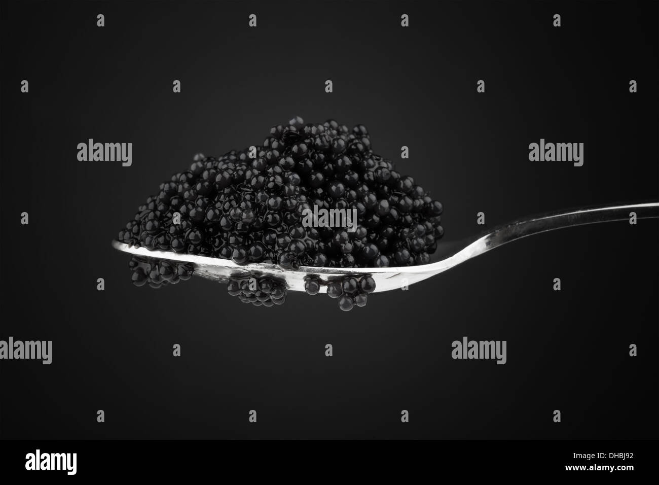 Schwarzer Kaviar in Metall Teelöffel. Makro-Foto auf dunklem Hintergrund Stockfoto