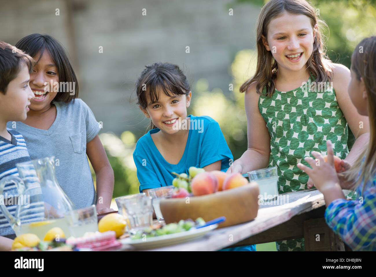 Eine Gruppe von Kindern an einem Tisch essen frisches Obst und Salate. Stockfoto