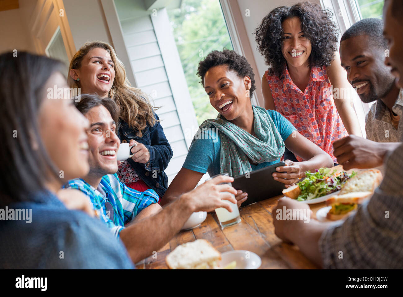 Eine Gruppe von Menschen treffen in einem Café für eine Mahlzeit. Verwenden digitale Tablets und Smartphones. Stockfoto