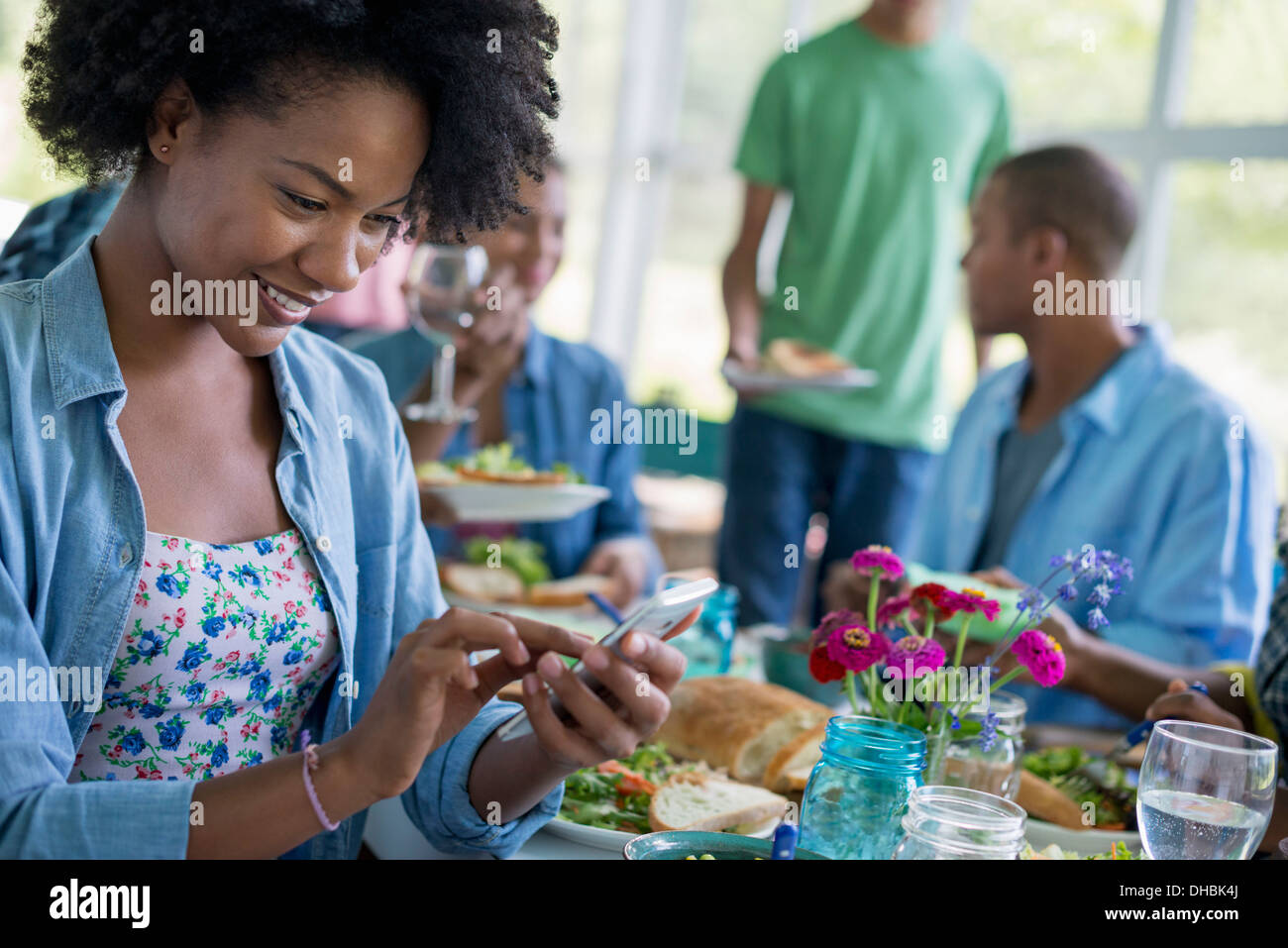 Eine Gruppe von Frauen und Männern an einem Tisch, die gemeinsame Mahlzeit in einer Landhausküche. Stockfoto