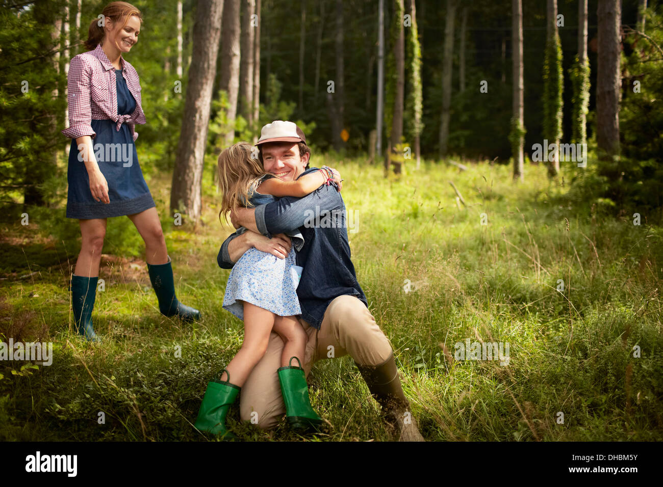 Ein Mann, ein kleines Kind umarmt. Eine Familie auf einem Waldspaziergang. Stockfoto