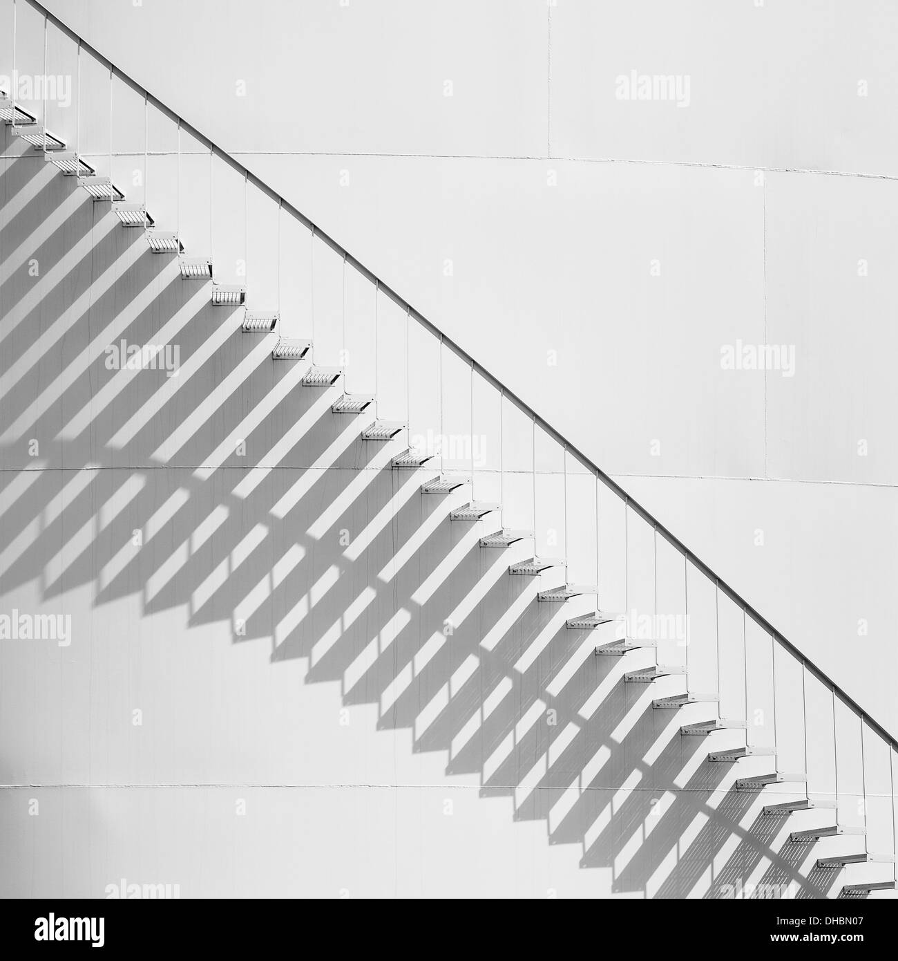 Treppe an der Seite von einem weißen Vorratsbehälter auf eine Öl-Raffinerie-Anlage. Ein Muster von Schatten. Stockfoto