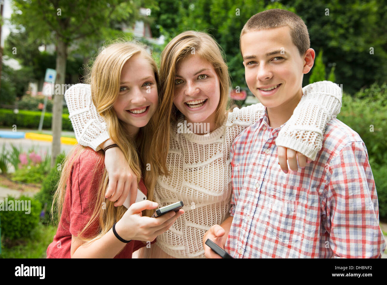 Drei junge Leute, zwei Mädchen und ein Junge, posiert und selfy fotografieren. Stockfoto