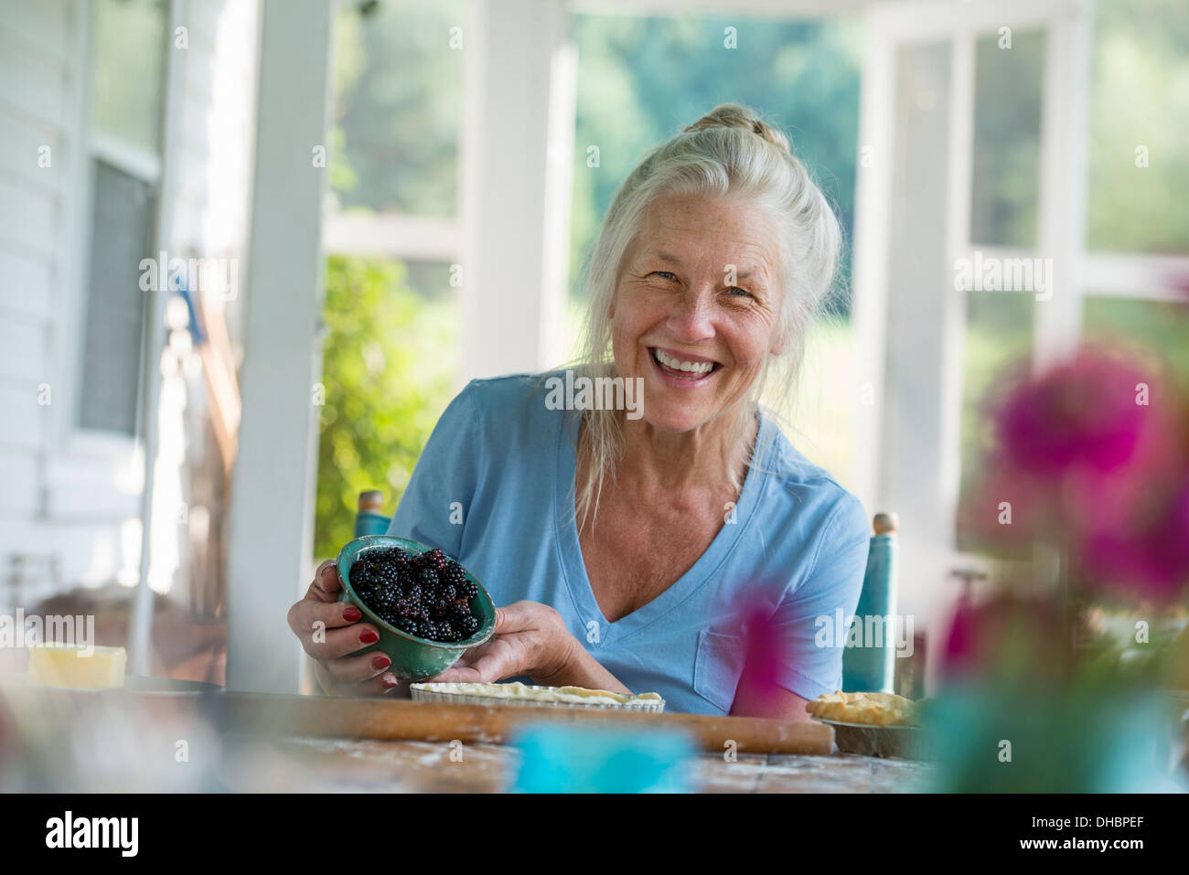 Ein Familienfest in einem Bauernhaus auf dem Land im Staat New York. Eine reife Frau mit Schale mit frischen Brombeeren. Stockfoto