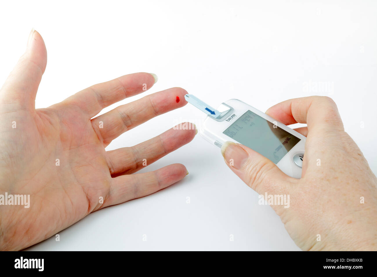 Diabetische Blut-Glucose-Test - mit einem Messgerät mit Blut am Finger-Tipp Stockfoto