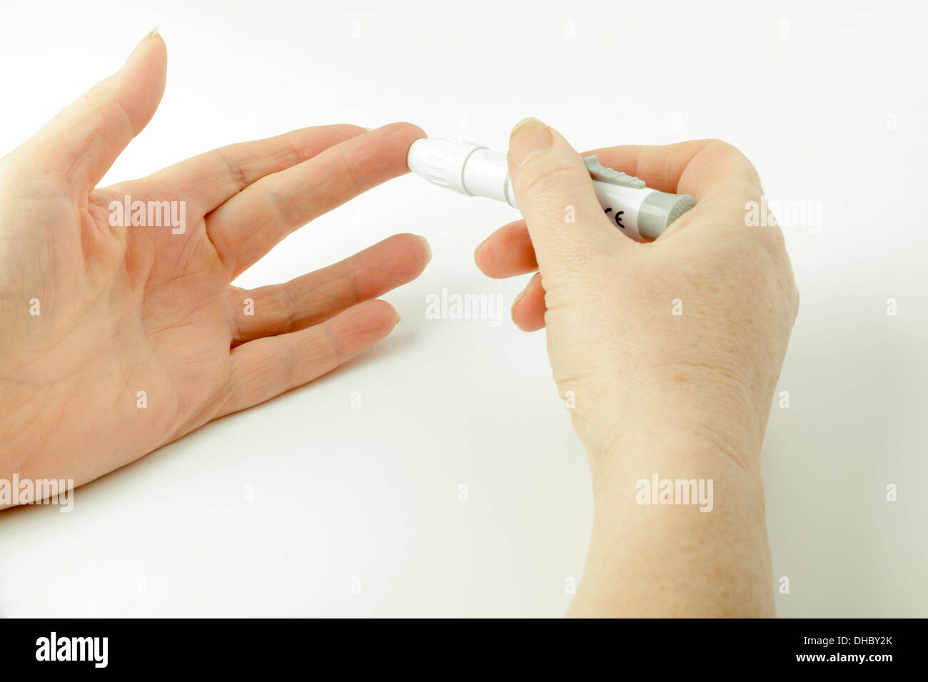 Diabetische Blutzuckermessung - mit einem Stich-Stick, Blut aus Finger zu extrahieren Stockfoto