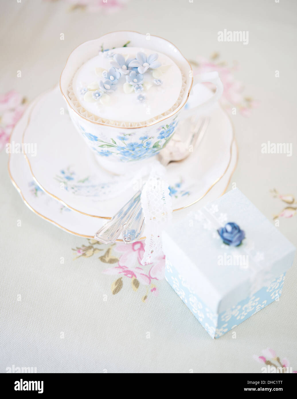 Eine florale China Tasse, Untertasse und Teller mit vereisten Cupcake und Cake box Stockfoto