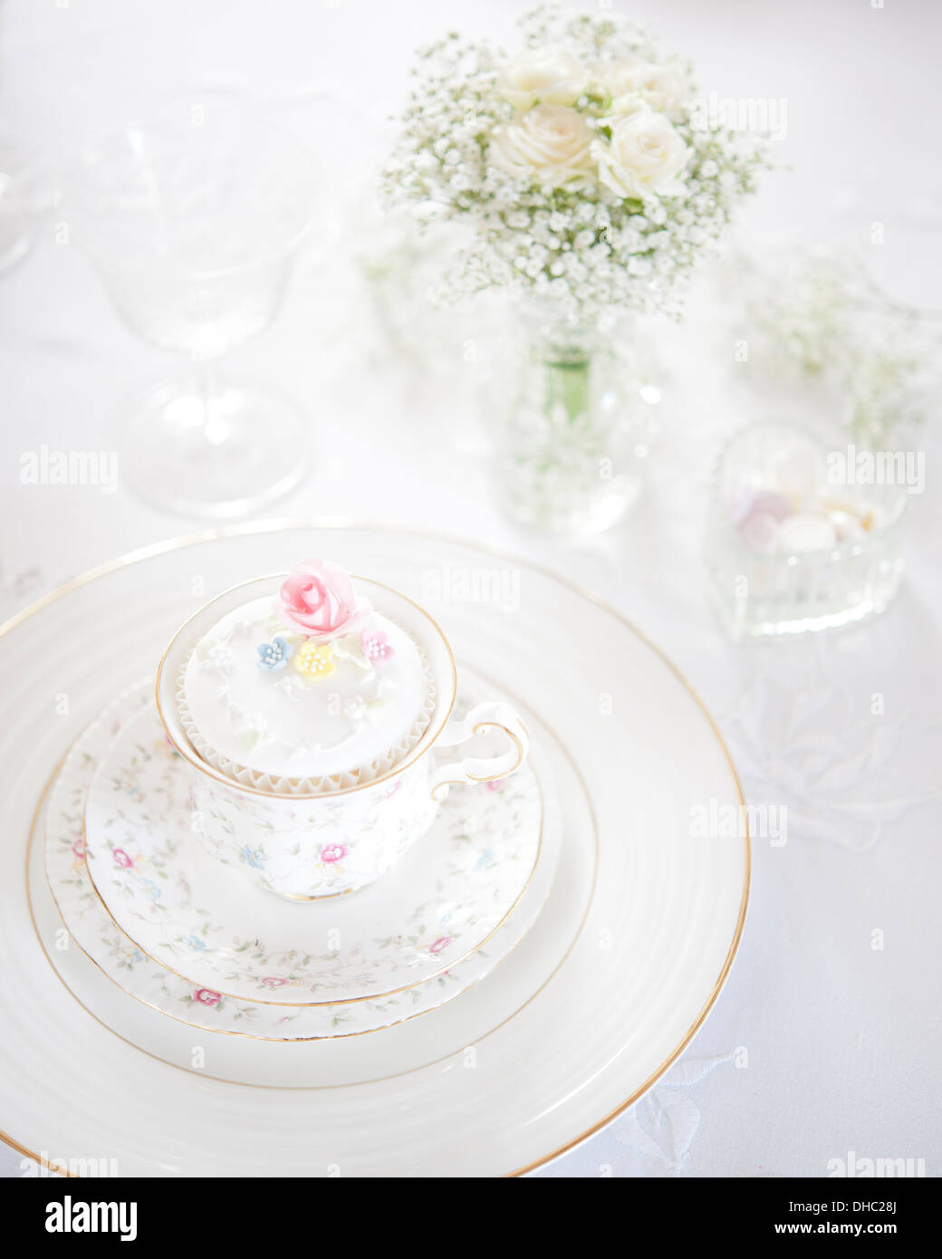 Eine Hochzeit Frühstück Gedeck mit China Teetasse, Cupcake und Vase mit weißen Blumen Stockfoto