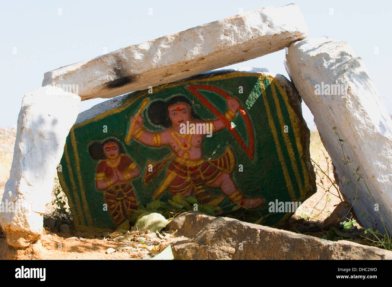 Straßenrand malte Stein Schrein zu Lord Rama mit Bogen und Mutter Sita im Hintergrund ländlichen Puttaparthi Andhara Pradesh in Indien Stockfoto