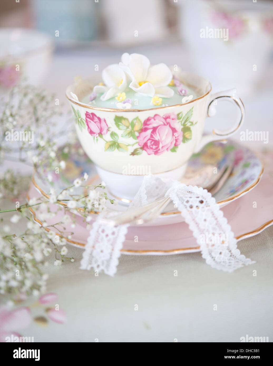 Eine florale China Tasse, Untertasse und Teller mit vereisten cupcake Stockfoto