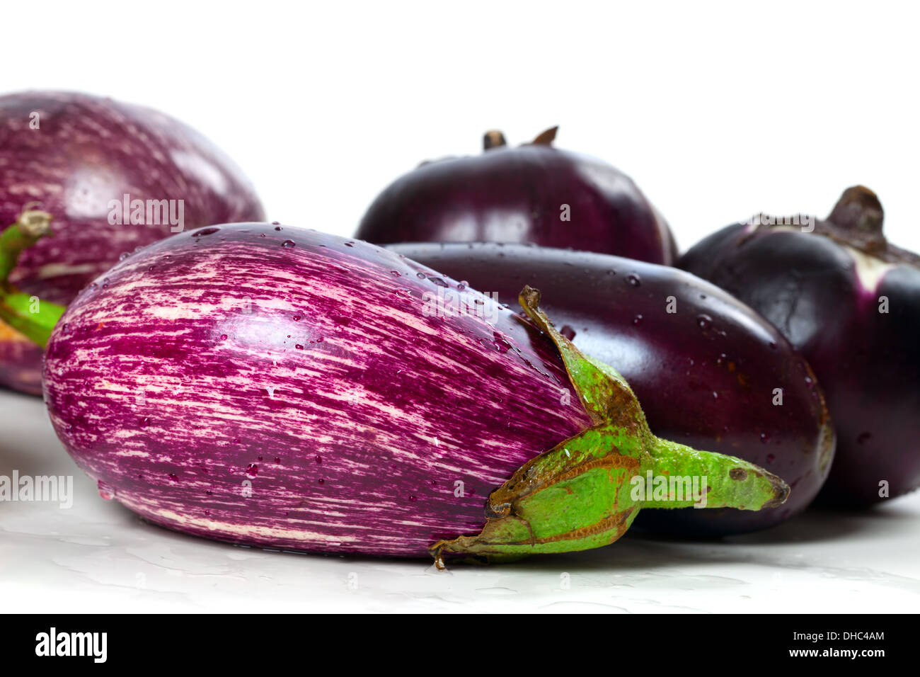 Verschiedene Sorten von Auberginen auf nassen weißen Hintergrund Stockfoto