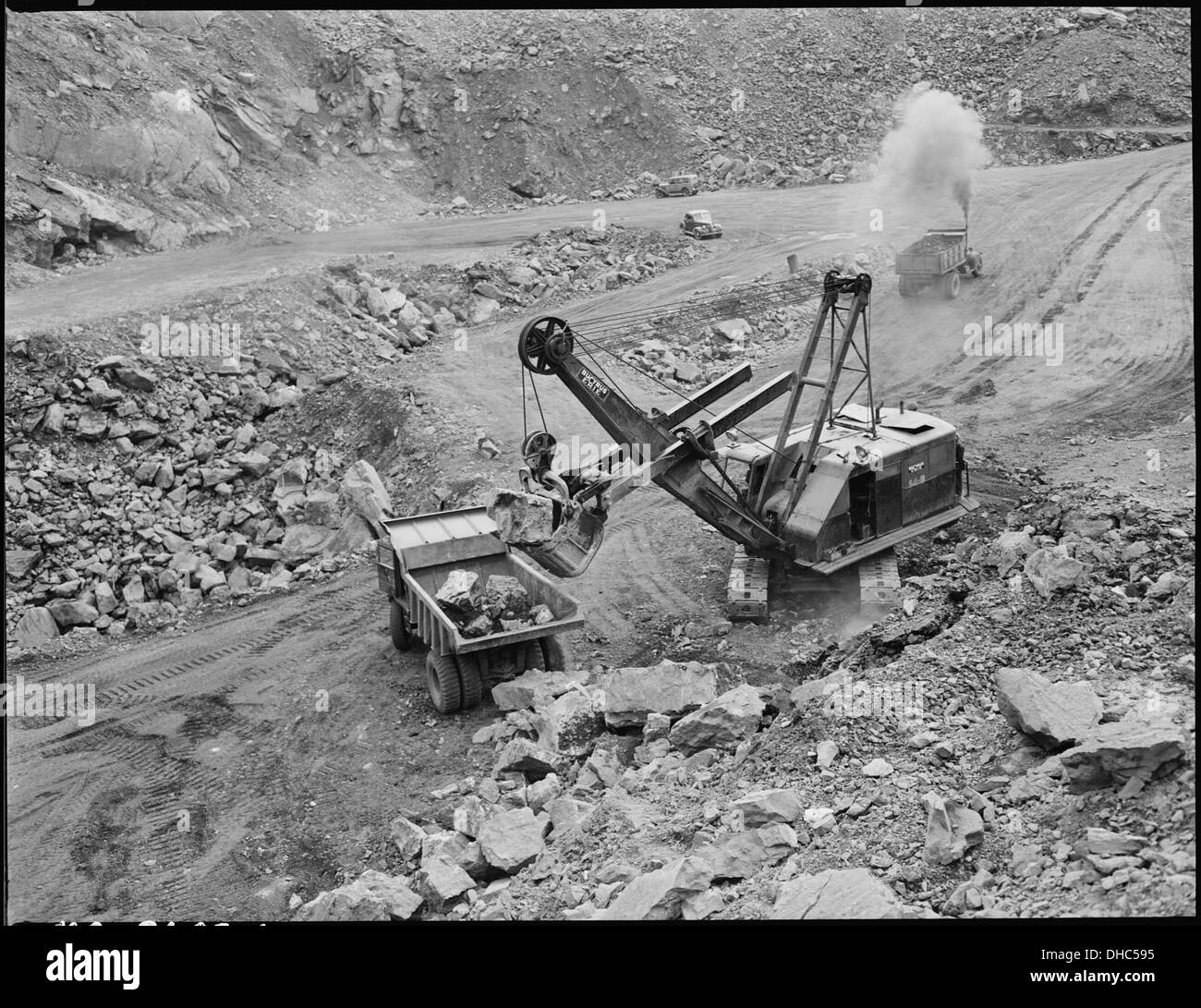 Dieses Bild zeigt eine große Schaufel, die während eines Streifenabbaubetriebs Gesteinsüberlagerungen entfernt und eine Kohleflöze freilegt. Die St. Clair Coal Company ist an diesem Prozess beteiligt, der Teil der Bergbaumethode ist, die für den Zugang zu Kohlevorkommen verwendet wird. Stockfoto Dieses Bild zeigt eine große Schaufel, die während eines Streifenabbaubetriebs Gesteinsüberlagerungen entfernt und eine Kohleflöze freilegt. Die St. Clair Coal Company ist an diesem Prozess beteiligt, der Teil der Bergbaumethode ist, die für den Zugang zu Kohlevorkommen verwendet wird. Stockfoto