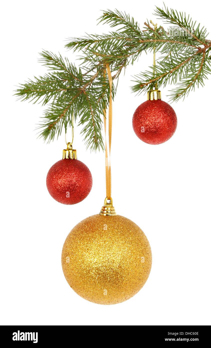Gold und rot glitter Weihnachtskugeln hängen aus dem Zweig eines Tannenbaums isoliert gegen weiß Stockfoto