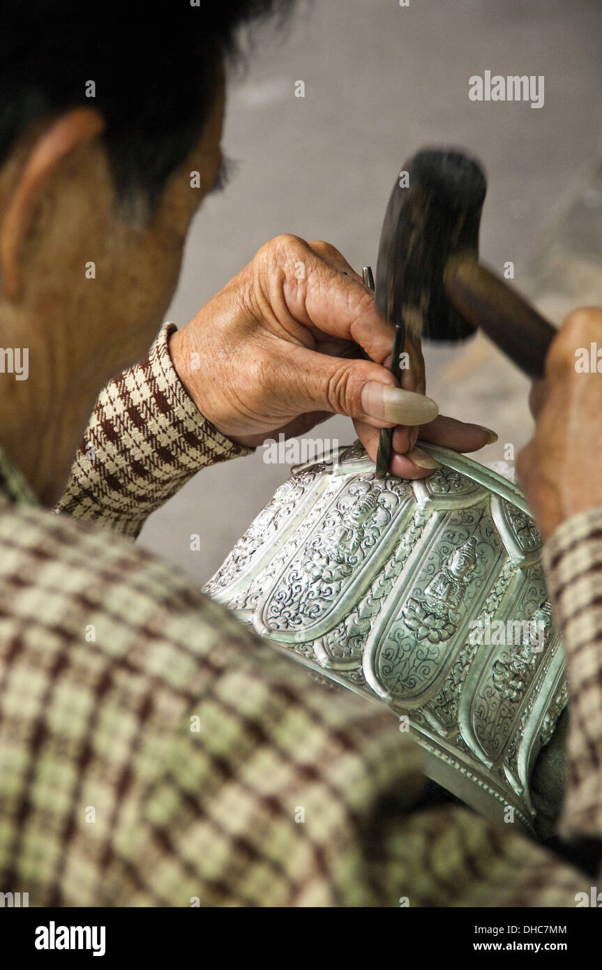 Vertikale Porträt von einem talentierten Silber Smith Gravur eine Silberschale in Laos. Stockfoto