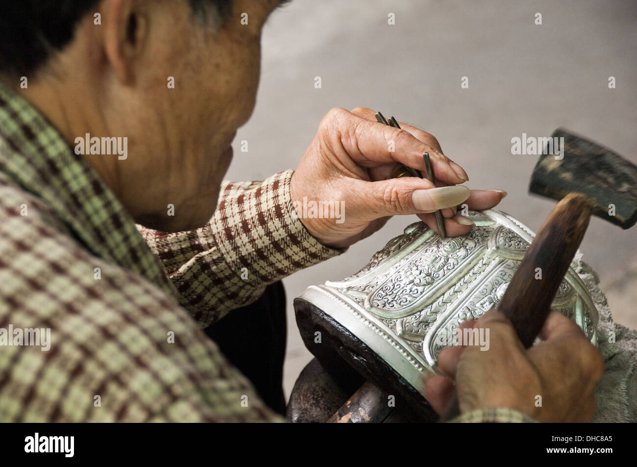 Horizontale Porträt von einem talentierten Silber Smith Gravur eine Silberschale in Laos. Stockfoto