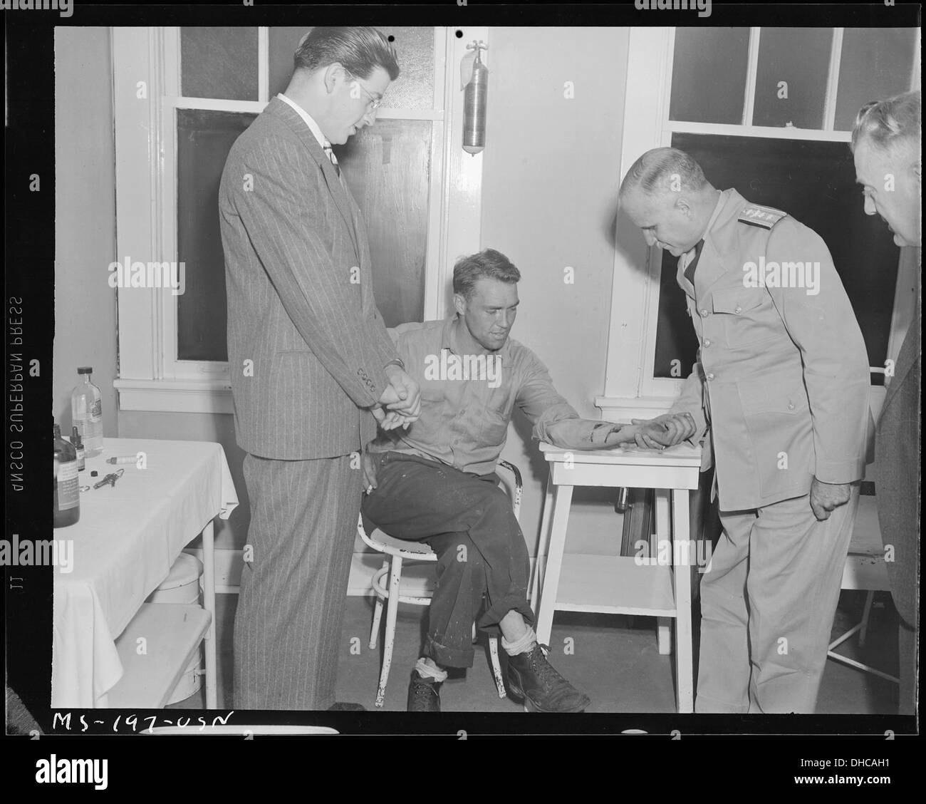 Konteradmiral Joel T. Boone befasst sich mit Arm von John Ketchum, Bauunternehmer, als Dr. W. S. Gibson, Betriebsarzt bohren... 540320 Stockfoto