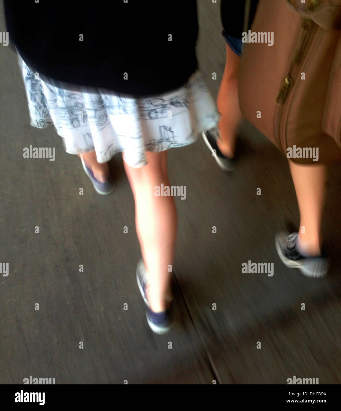 Rückansicht der beiden Pre-Teen Mädchen zu Fuß auf dem Bürgersteig, High Angle View der Beine und Füße Stockfoto
