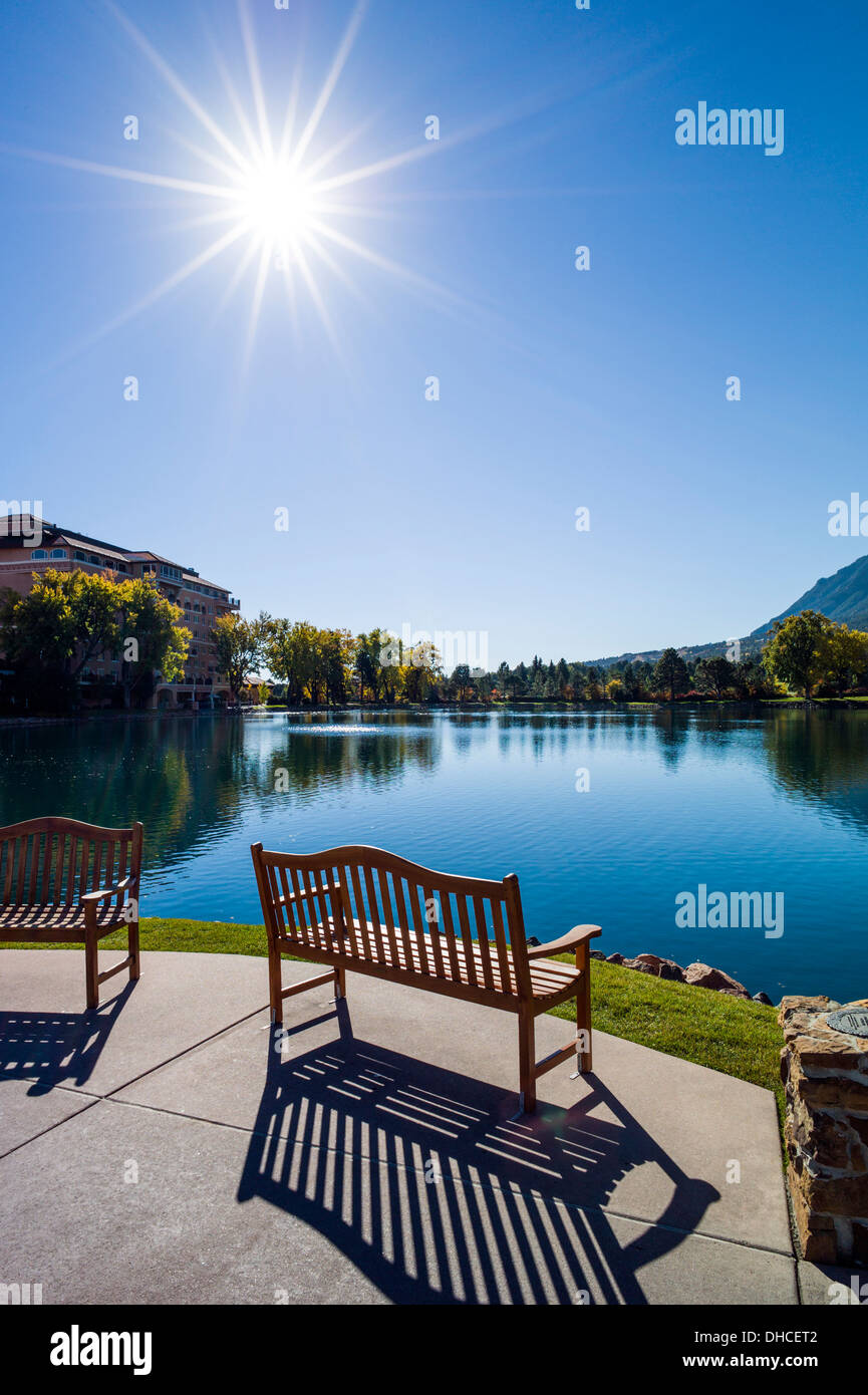Verwitterte Holzbank mit Blick auf Cheyenne See, The Broadmoor, historische Luxus-Hotel und Resort, Colorado Springs, Colorado, USA Stockfoto