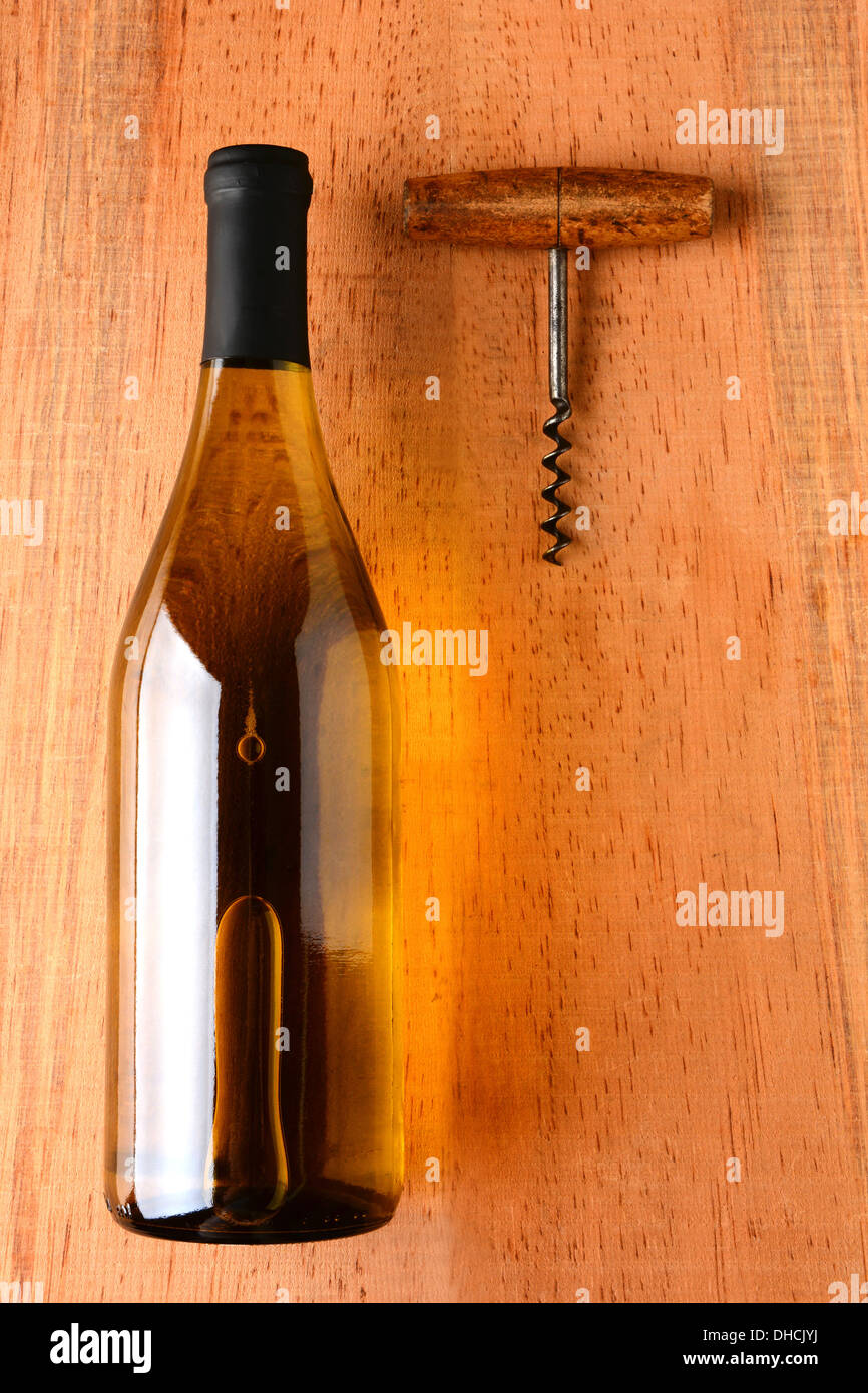 Eine Flasche Chardonnay Wein und Korkenzieher auf rustikale Oberfläche des Holzes. Die Flasche hat keine Bezeichnung Stockfoto