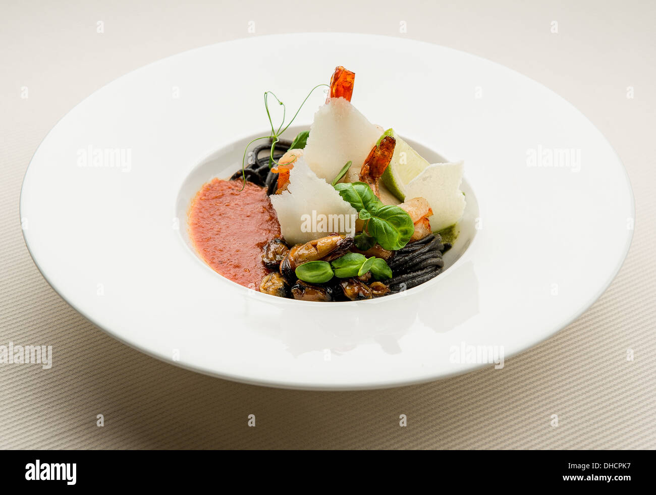 Schwarze Spaghetti mit Meeresfrüchten, Parmesan und Tomatensauce Stockfoto