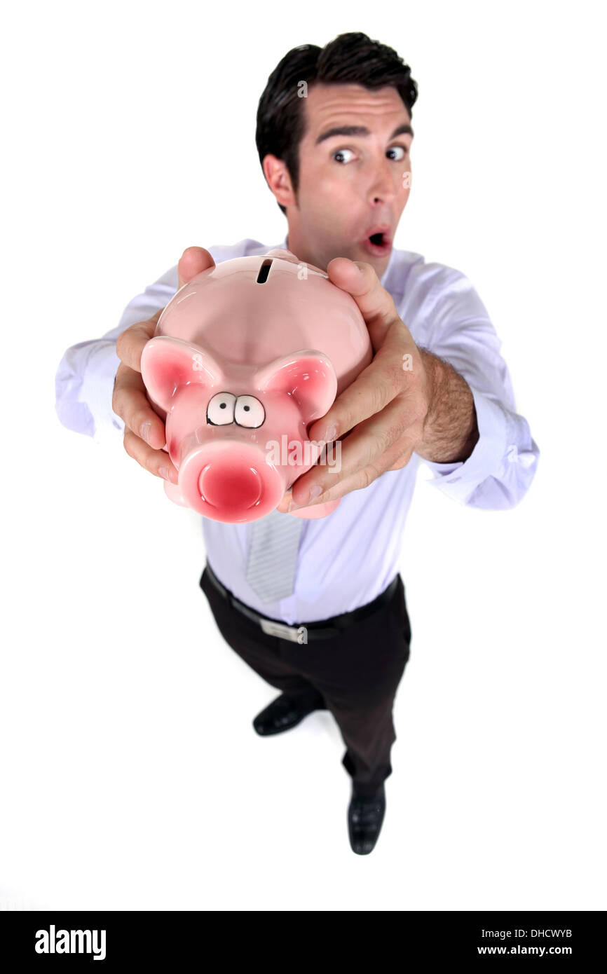 Ein Geschäftsmann hält ein Sparschwein. Stockfoto